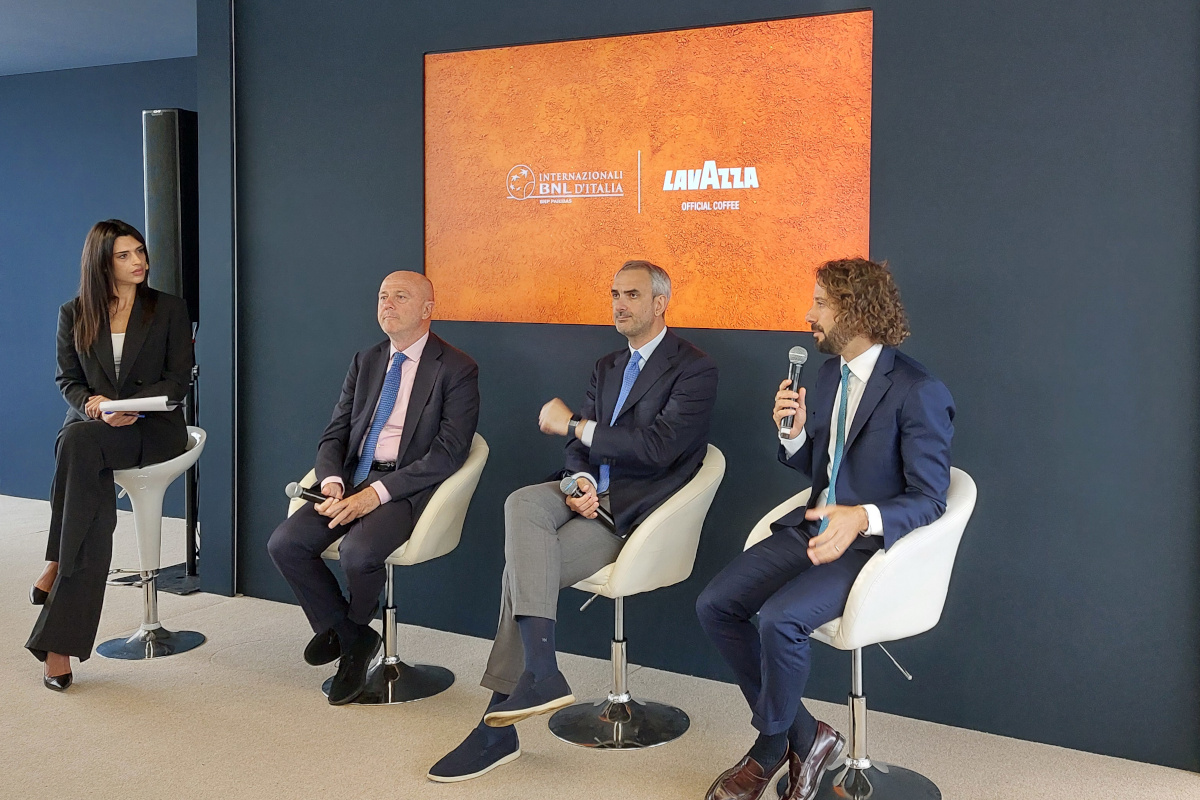 Presentazione Lavazza agli Internazionali di Tennis a Roma. Uomini in giacca e cravatta e donna seduti.