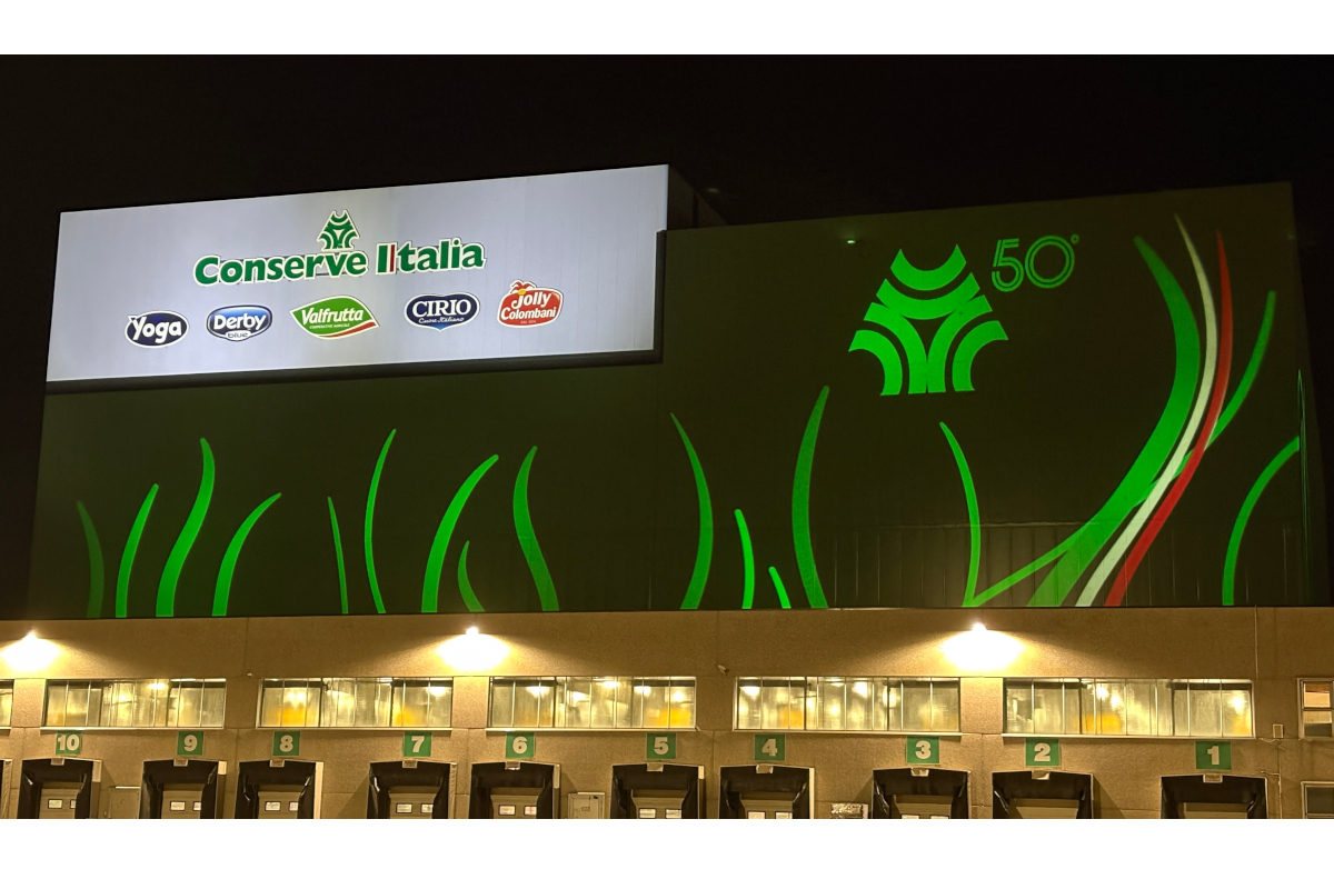 Conserve Italia: stabilimento Pomposa illuminato per il 50° anniversario. Logo Conserve Italia e marchi Yoga, Derby, Cirio, Valfrutta.