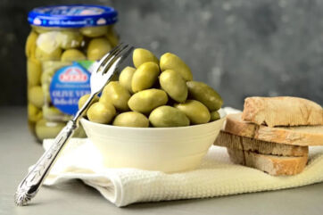 Olive Neri Sottoli in ciotola con pane. Nesti Conserve salva il marchio.