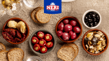 Tavola Neri Sottoli con antipasti toscani: pomodori secchi, carciofi, cipolline, olive, funghi e peperoncini ripieni.
