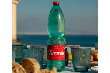 Bottiglia Ferrarelle con bicchieri. Acqua minerale effervescente naturale Ferrarelle, ricavi a 250 milioni.