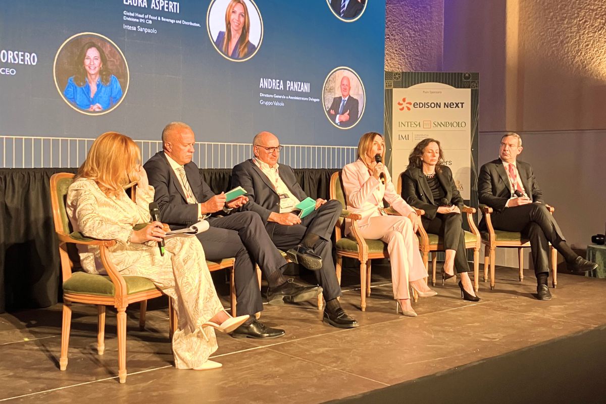 Panel di esperti al Food Summit 2026. Oratori discutono di volatilità e valore durevole.