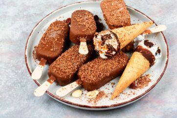 Gelato confezionato: coni e stecchi di gelato al cioccolato su piatto. Dessert estivo, dolci freddi.