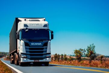 Camion Scania bianco su strada. Logistica e trasporti efficienti per la crescita del settore alimentare. #logistica #trasporti #IA