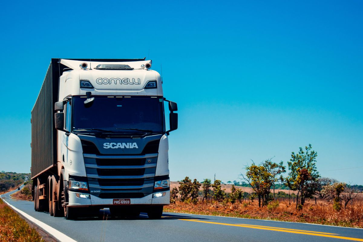 Camion Scania bianco su strada. Logistica e trasporti efficienti per la crescita del settore alimentare. #logistica #trasporti #IA