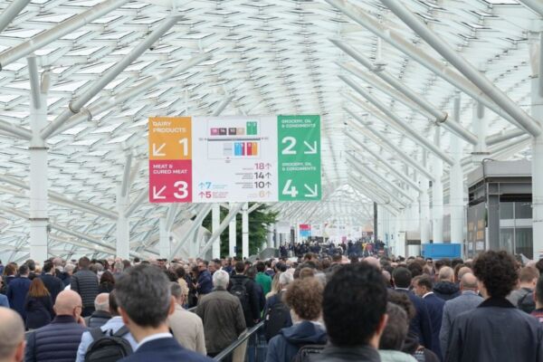 Folla a Tuttofood 2026, fiera alimentare a Milano. Stand prodotti lattiero-caseari, carne, oli e condimenti.