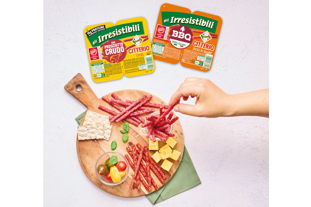 Snack Citterio Gli Irresistibili: bastoncini di salame e prosciutto crudo su tagliere con formaggio e pomodorini.