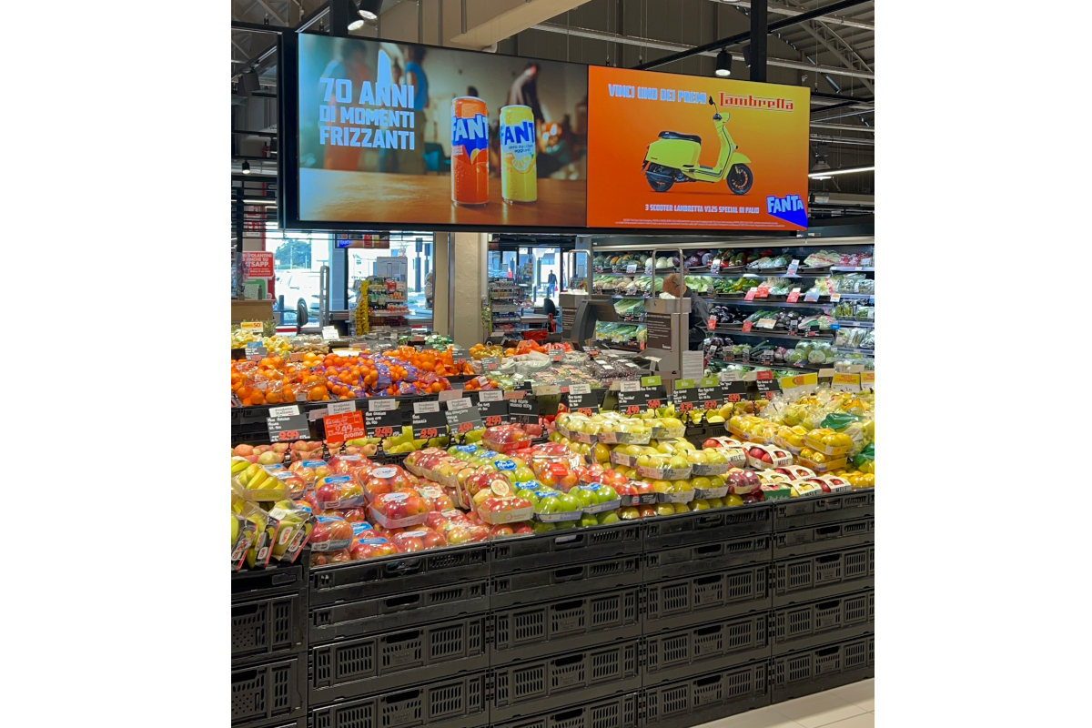 Reparto ortofrutta in un punto vendita Gruppo Selex con cartellonistica promozionale Fanta e concorso a premi Lambretta.