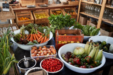 Gastronomia sostenibile: verdure fresche e prodotti locali in cassette di legno per ridurre lo spreco alimentare nella Gdo