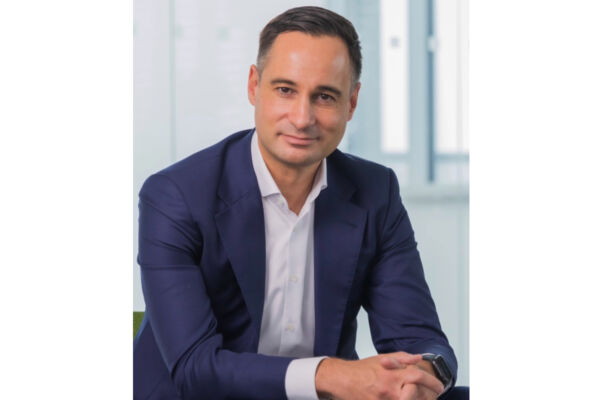 Michael Maddalena, nuovo Chief Operations Officer di Penny Italia, in giacca blu e camicia bianca in ufficio.