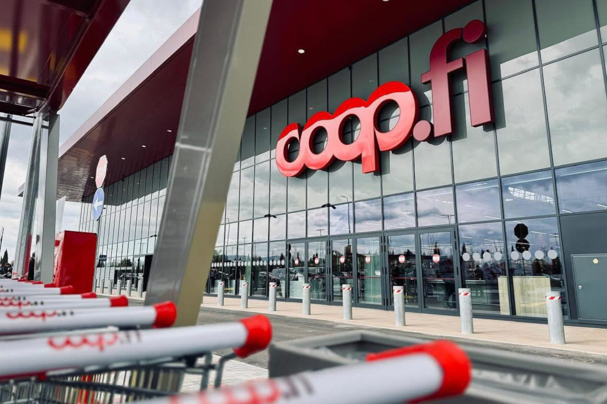 Facciata esterna di un supermercato Unicoop Firenze con logo coop.fi e carrelli della spesa in primo piano.