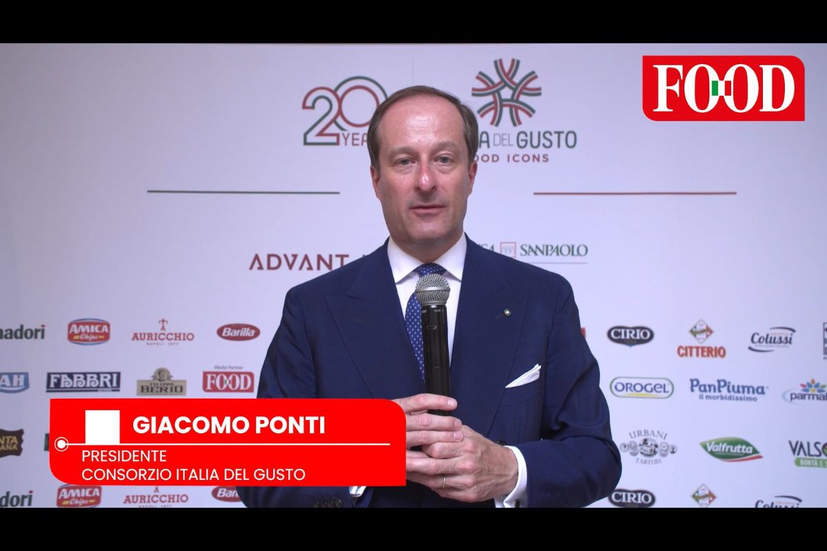 Giacomo Ponti, Presidente di Italia del Gusto, parla a un evento dell'eccellenza alimentare italiana con loghi sponsor.