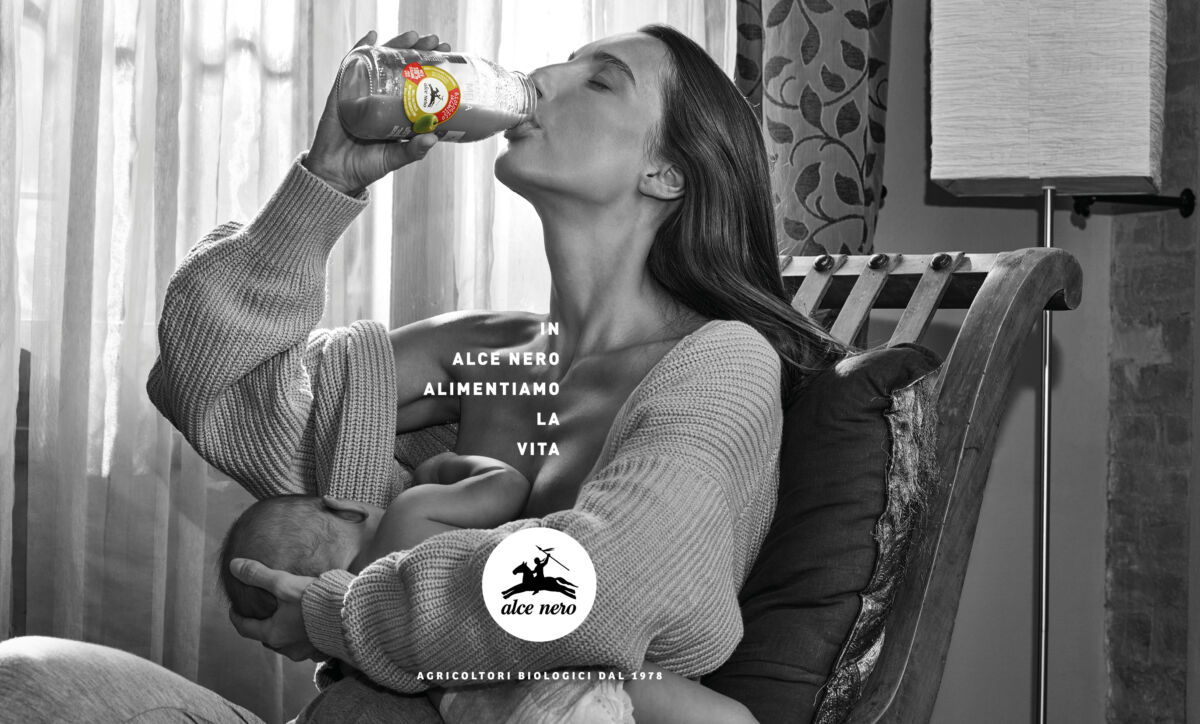 Donna beve integratore alimentare Alce Nero mentre allatta il suo bambino, campagna Alimentiamo la vita, stile bio.