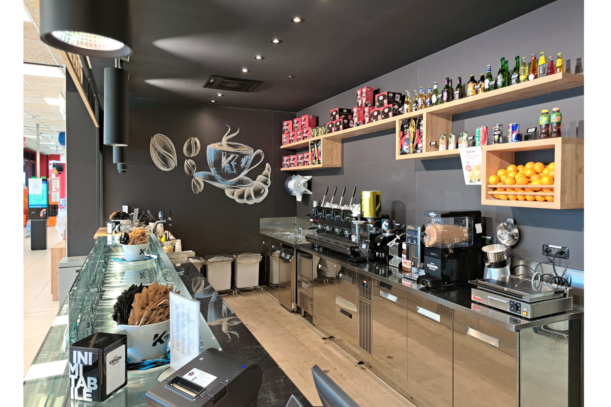 Bistrot Famila Gruppo Megamark a Bari: bancone bar moderno con macchina caffè, esposizione bevande e decorazioni a muro.