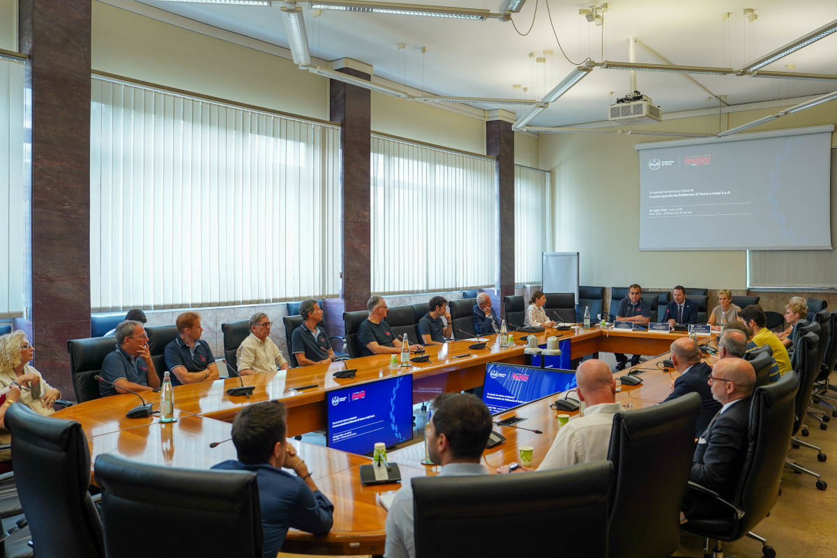 Riunione istituzionale tra Politecnico di Torino e Inalpi in una sala conferenze con tavolo a ferro di cavallo.