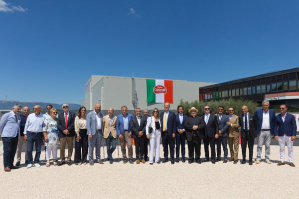 Inaugurazione del nuovo stabilimento Pietro Coricelli a Spoleto con un gruppo di autorità e dirigenti davanti all'azienda.