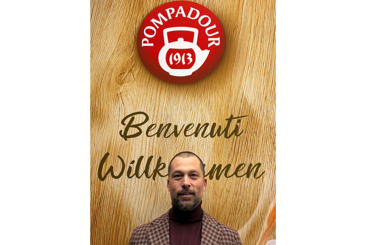 Paolo Maria Romano, nuovo Amministratore Delegato di Pompadour, davanti al logo aziendale su sfondo in legno.