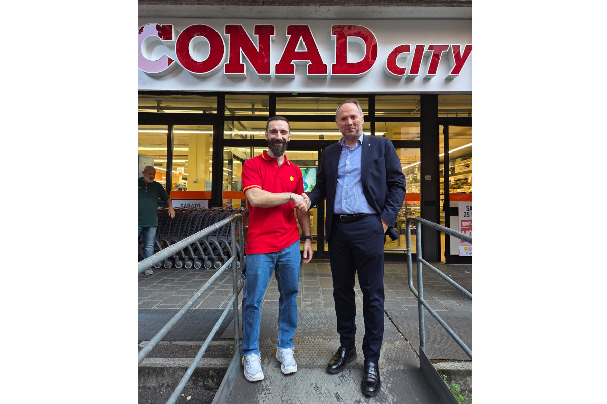 Inaugurazione Conad City a Modena: due uomini si stringono la mano davanti all'ingresso del nuovo punto vendita Conad.