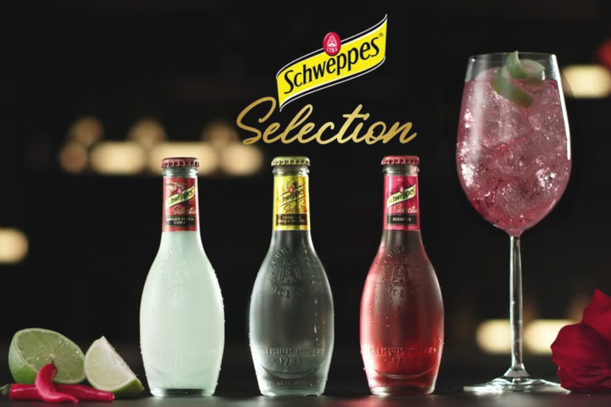 Tre bottiglie di Schweppes Selection e un cocktail in un calice, ideali per home tending e mixology premium.