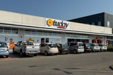 Facciata esterna del nuovo supermercato Tuday Conad a Montecchio Emilia con parcheggio antistante e auto in sosta.