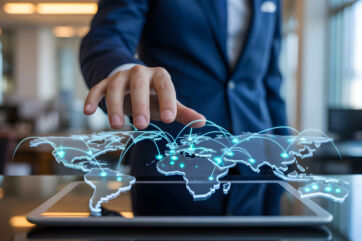 Manager in giacca interagisce con una mappa del mondo digitale olografica per l'espansione internazionale di Investindustrial.
