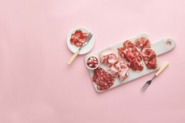 Selezione di salumi di alta gamma su tagliere di marmo, con meno sale per un benessere senza compromessi.