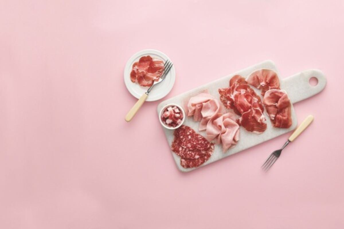 Selezione di salumi di alta gamma su tagliere di marmo, con meno sale per un benessere senza compromessi.