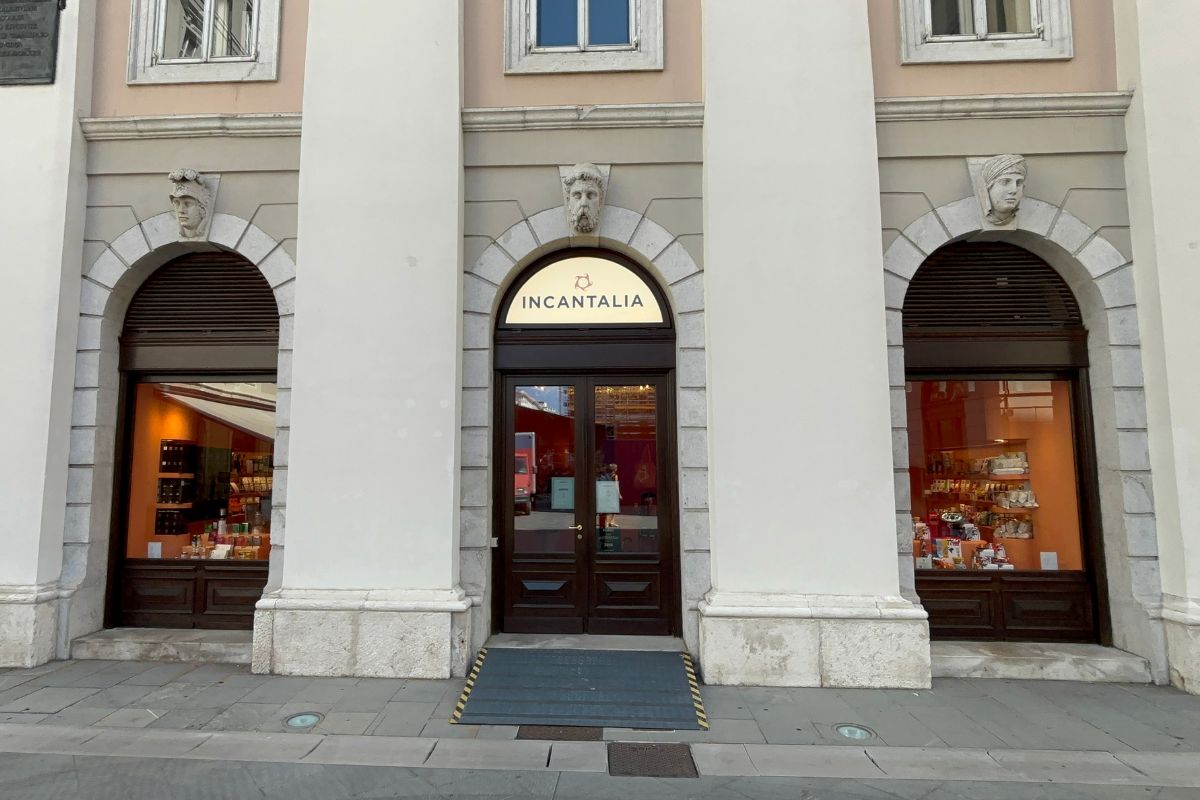 Facciata del negozio Incantalia con vetrine, portone ad arco e dettagli architettonici classici nel retail di lusso.