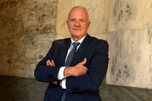 Andrea Panzani, amministratore delegato di Valsoia, in giacca e cravatta davanti a una parete di marmo.