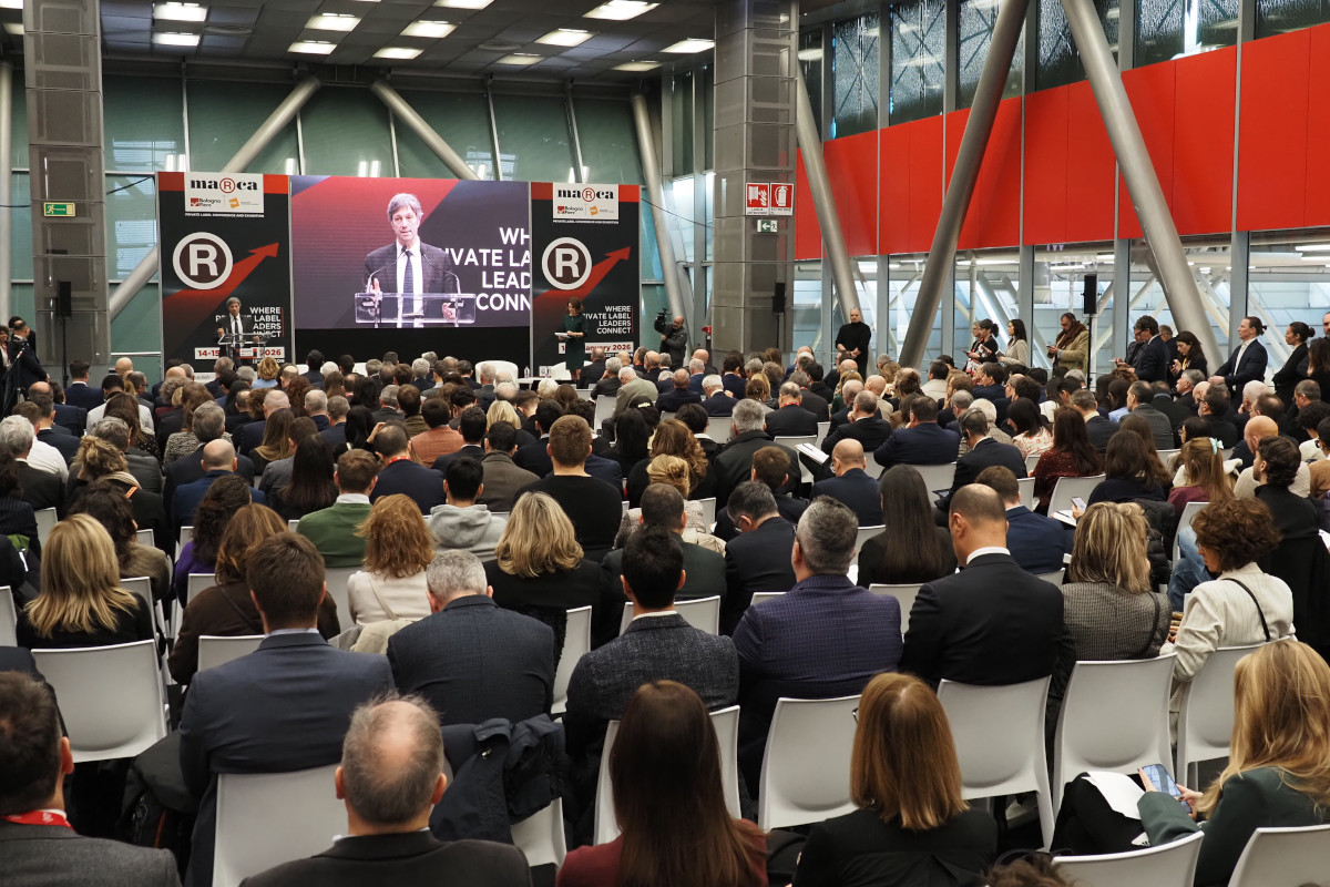 Conferenza Marca by BolognaFiere: pubblico numeroso segue l'intervento di un relatore sul palco. Evento business di settore.