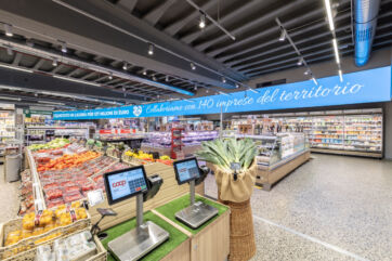 Illuminazione Imoon nel supermercato Coop Waterfront di Genova: reparto ortofrutta con bilance e insegna promozionale.