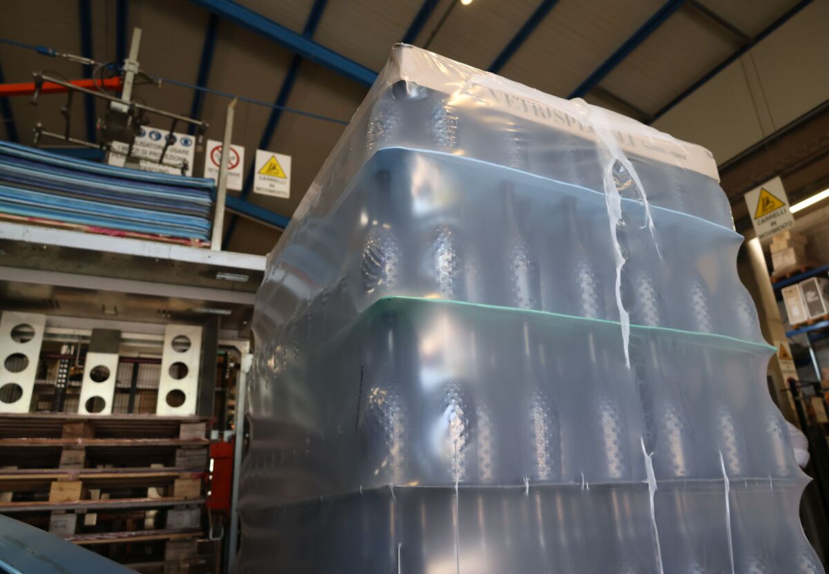Bancale di bottiglie avvolto in film plastico riciclato Aliplast per il packaging sostenibile di Cantina Pizzolato.