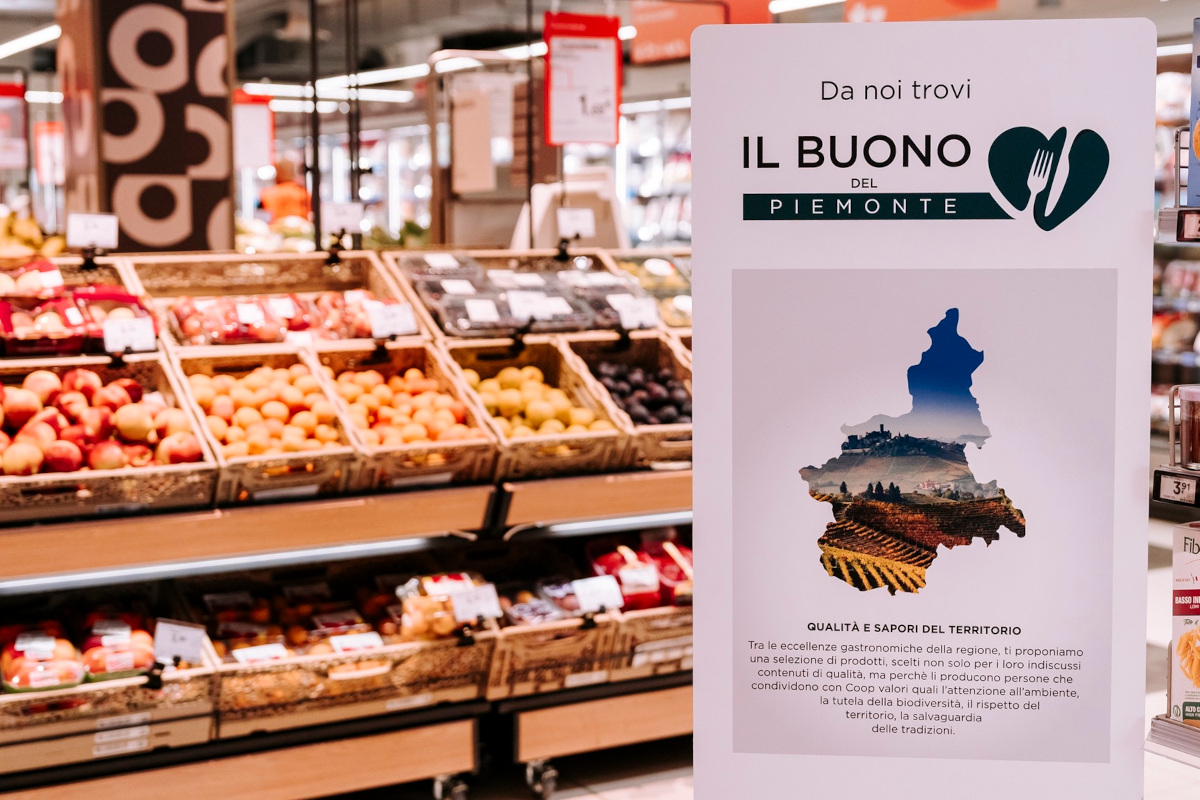 Cartello Il Buono del Piemonte con mappa regionale e cuore, reparto ortofrutta Nova Coop con mele e prodotti locali
