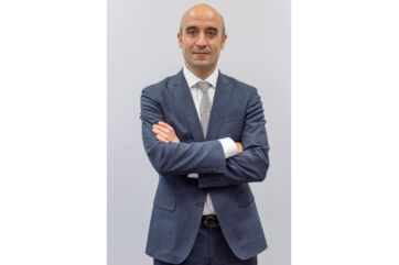 Ritratto di Daniele Del Gobbo, nuovo Direttore risorse umane del Gruppo Gabrielli, in abito blu a braccia conserte