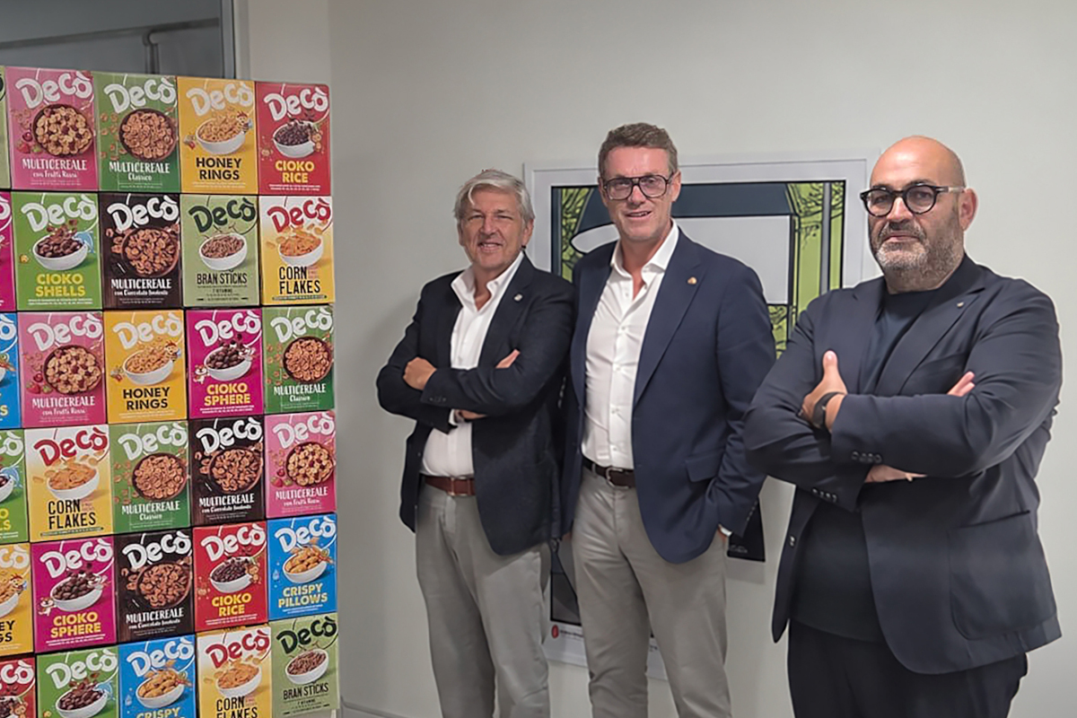 Arena, Antley e Nicotra celebrano i 20 anni di Decò davanti a una parete di cereali per il SuperConcorso nazionale.