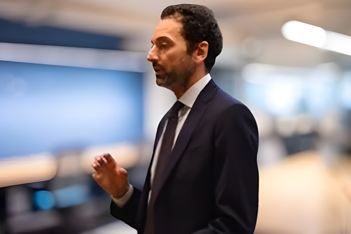 Emiliano Laricchiuta, nuovo Head of Group Marketing di Ferrero, in giacca e cravatta durante un intervento in ufficio.