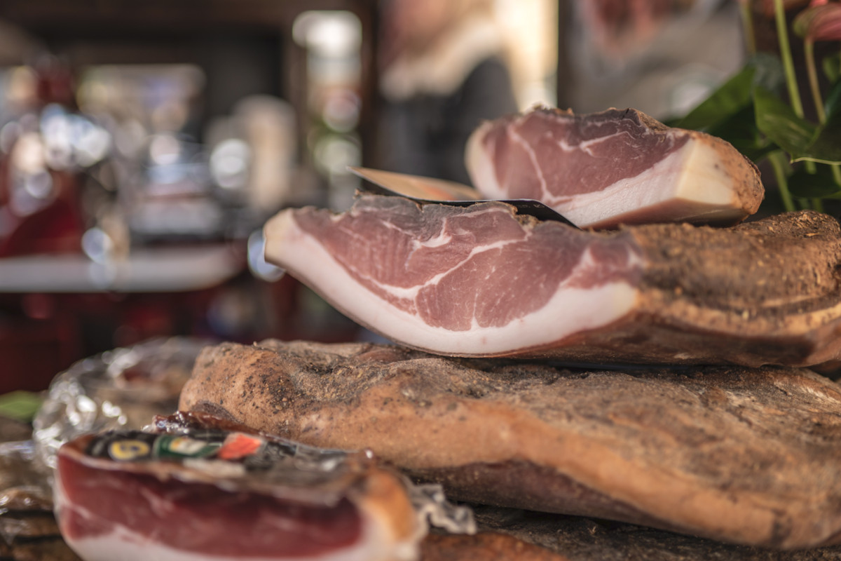 Tranci di speck dell'Alto Adige tagliati a fette, esposti in primo piano durante la Festa dello Speck.