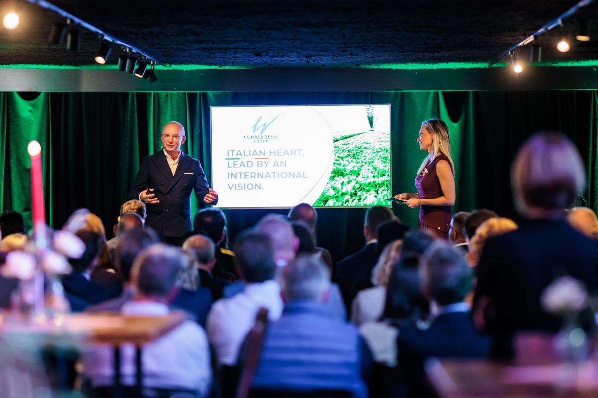 Il CEO Domenico Battagliola sul palco presenta La Linea Verde Benelux durante un evento aziendale.