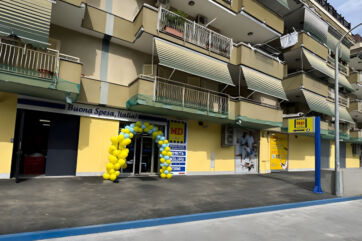 Facciata del punto vendita MD a Mugnano di Napoli con arco di palloncini gialli e blu per la riapertura del supermercato.