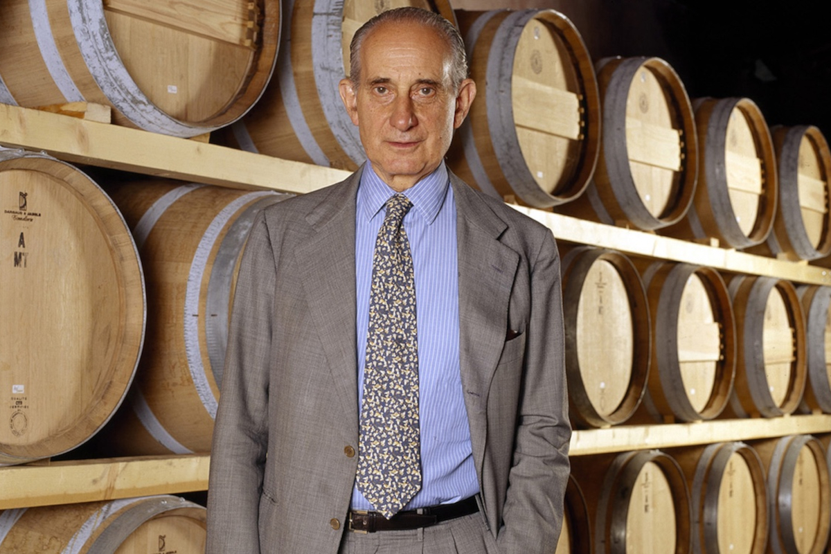Vittorio Frescobaldi, icona del vino toscano, ritratto in una cantina storica circondato da botti di legno di rovere.