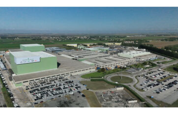 Veduta aerea dello stabilimento Conserve Italia di Pomposa (FE): edifici industriali, parcheggi e campi agricoli circostanti.