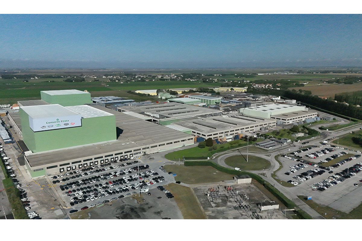 Veduta aerea dello stabilimento Conserve Italia di Pomposa (FE): edifici industriali, parcheggi e campi agricoli circostanti.