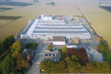 Veduta aerea del nuovo stabilimento del Gruppo Fini a Ravarino, con pannelli solari sul tetto e parcheggio.