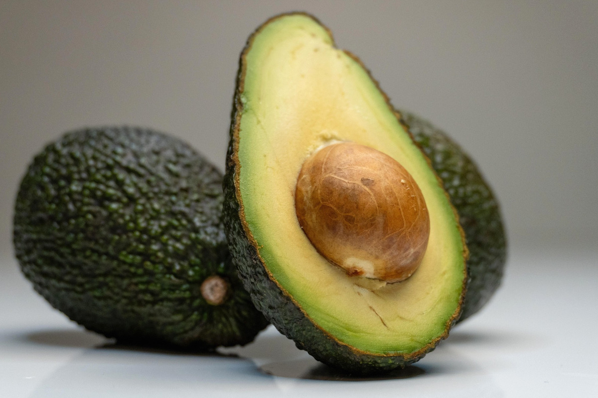 Avocado fresco tagliato a metà con nocciolo, mercato europeo e qualità del prodotto ortofrutticolo
