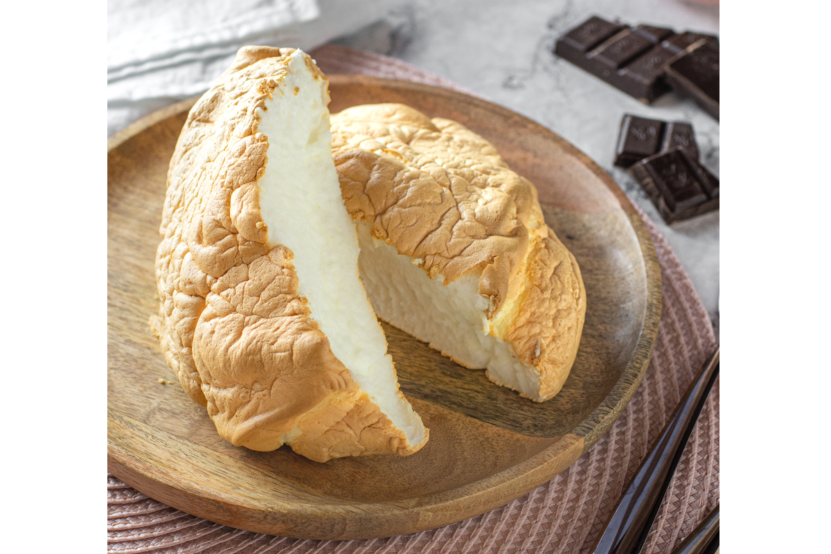 CloudBread® tagliato su piatto di legno con ripieno cremoso, cioccolato fondente e bacchette