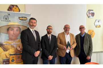 Conapi vince il Generative Business Award: quattro uomini posano con il premio davanti al banner Mielizia.