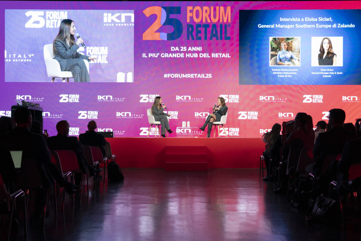 Forum Retail 2026: palco con speaker e intervista su intelligenza artificiale nel retail, pubblico in sala e schermi con hashtag Forum Retail 25.