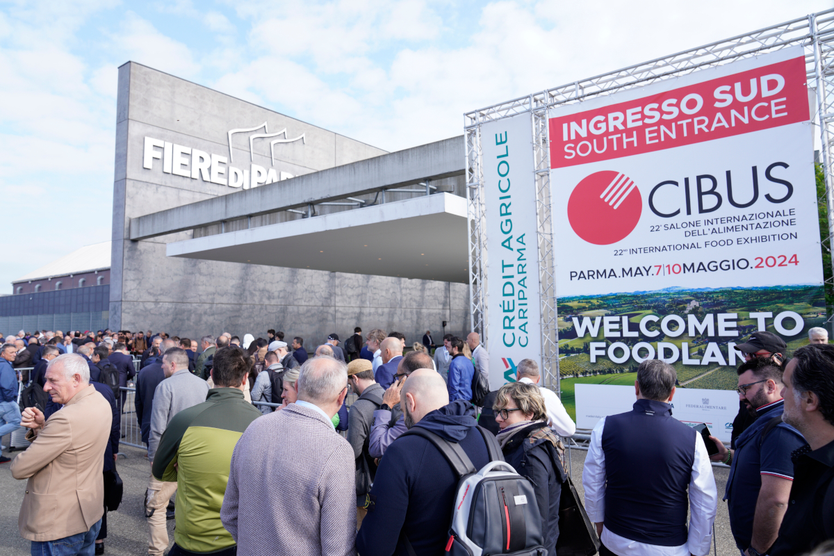 Ingresso Sud Fiere di Parma affollato con visitatori e striscione Cibus 2024, salone internazionale food Made in Italy