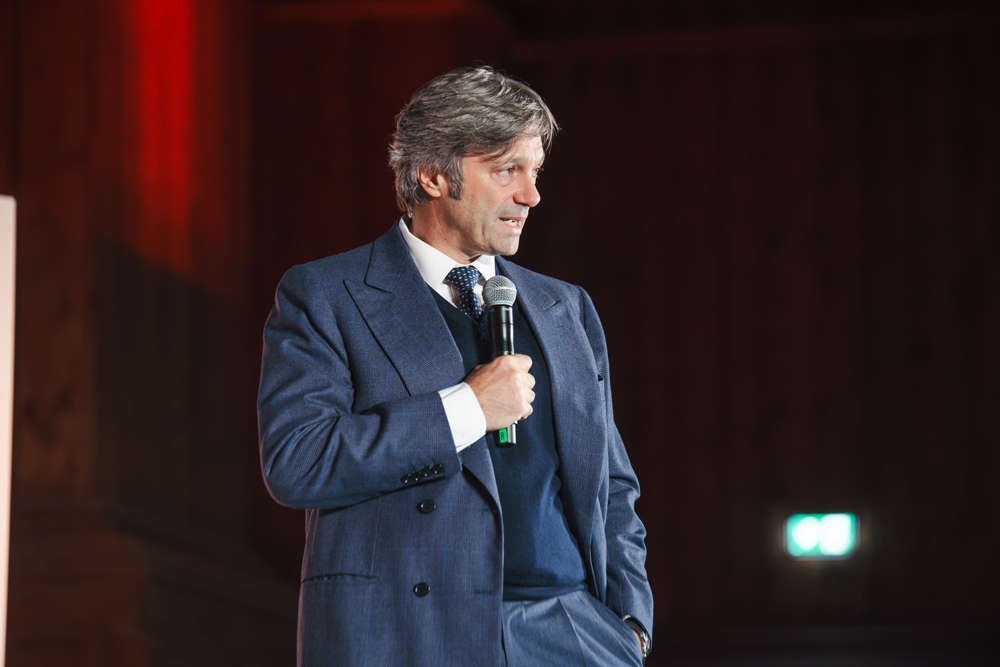 Uomo in abito blu parla al microfono durante i 35 anni di Food al Teatro Farnese