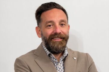 Ritratto di Tommaso Pesante, nuovo IT Manager di Dit, con barba e giacca beige su sfondo bianco